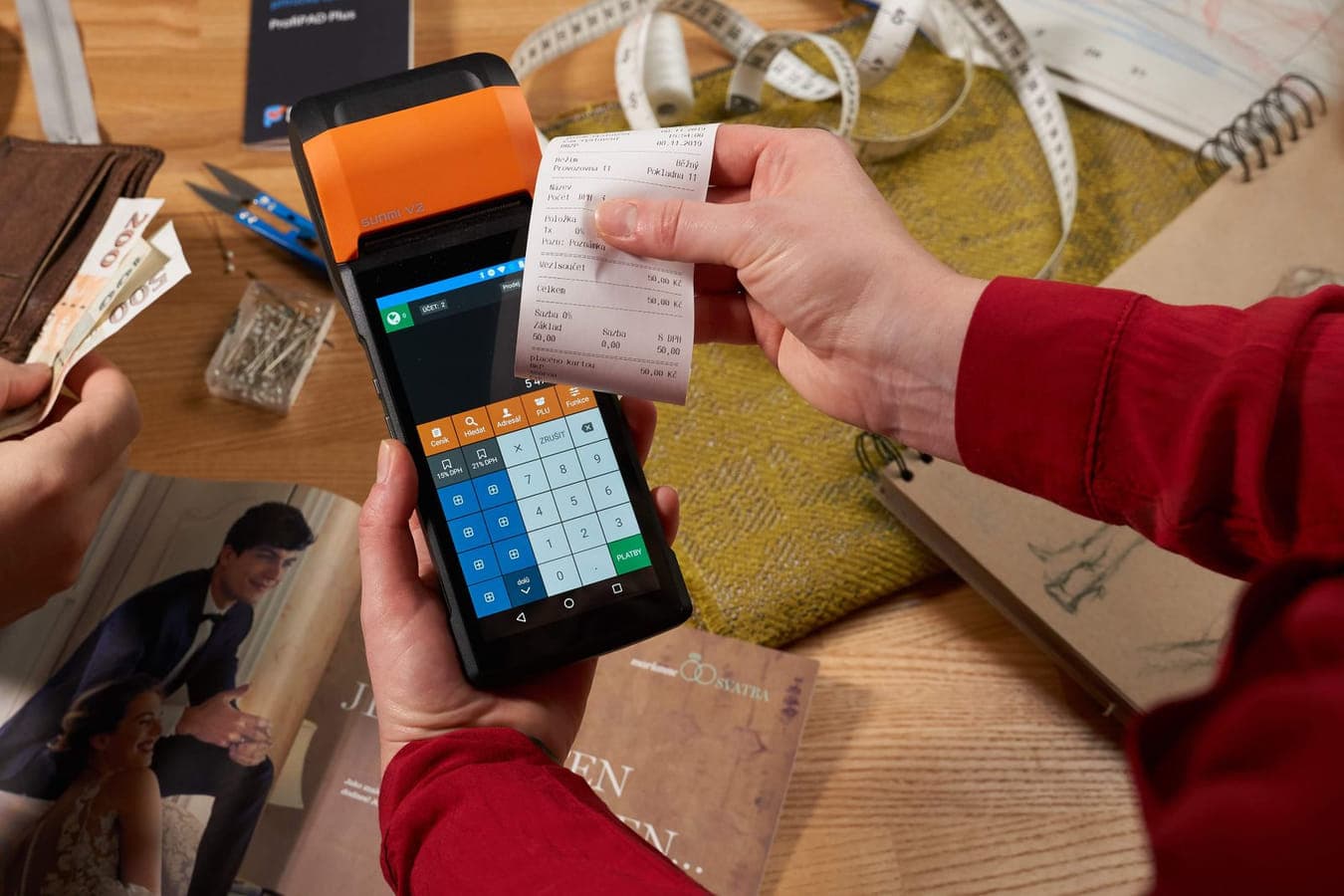 A handheld order terminal with a printed ticket torn off it